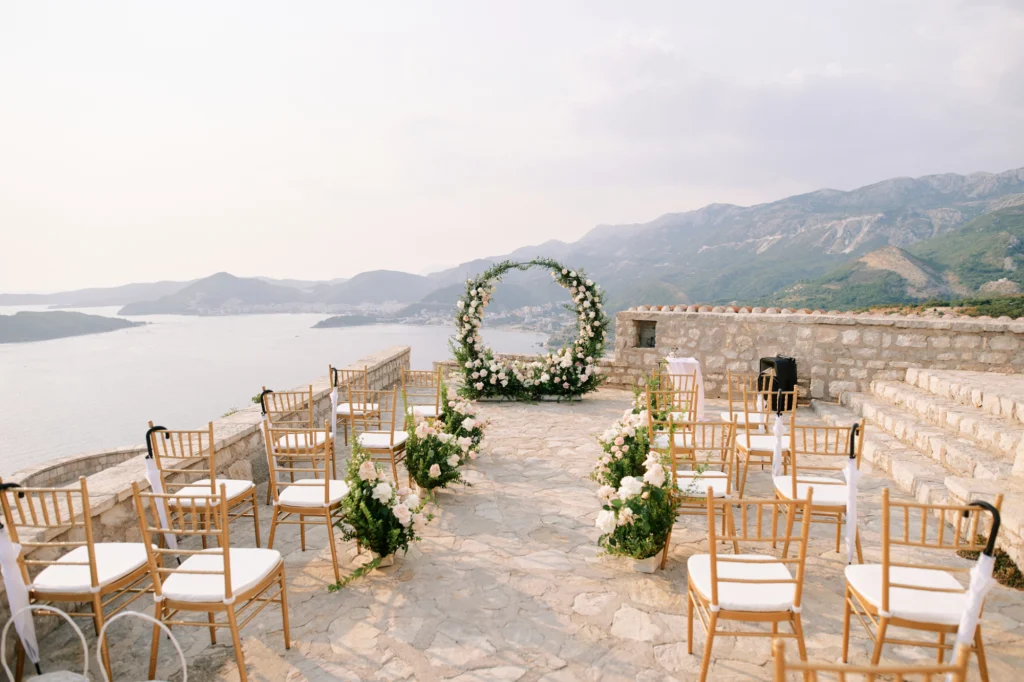 A wedding ceremony with chairs and flowers