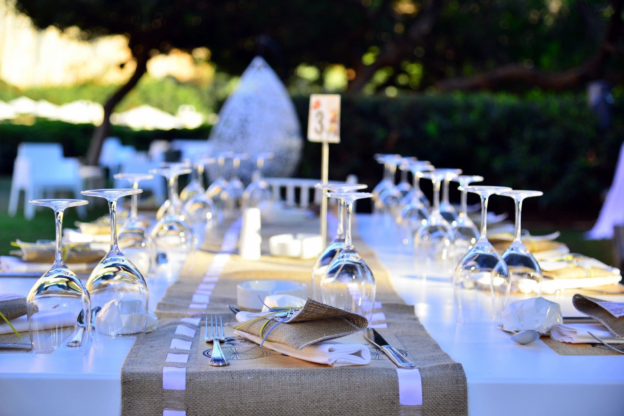 A table set with wine glasses and napkins.