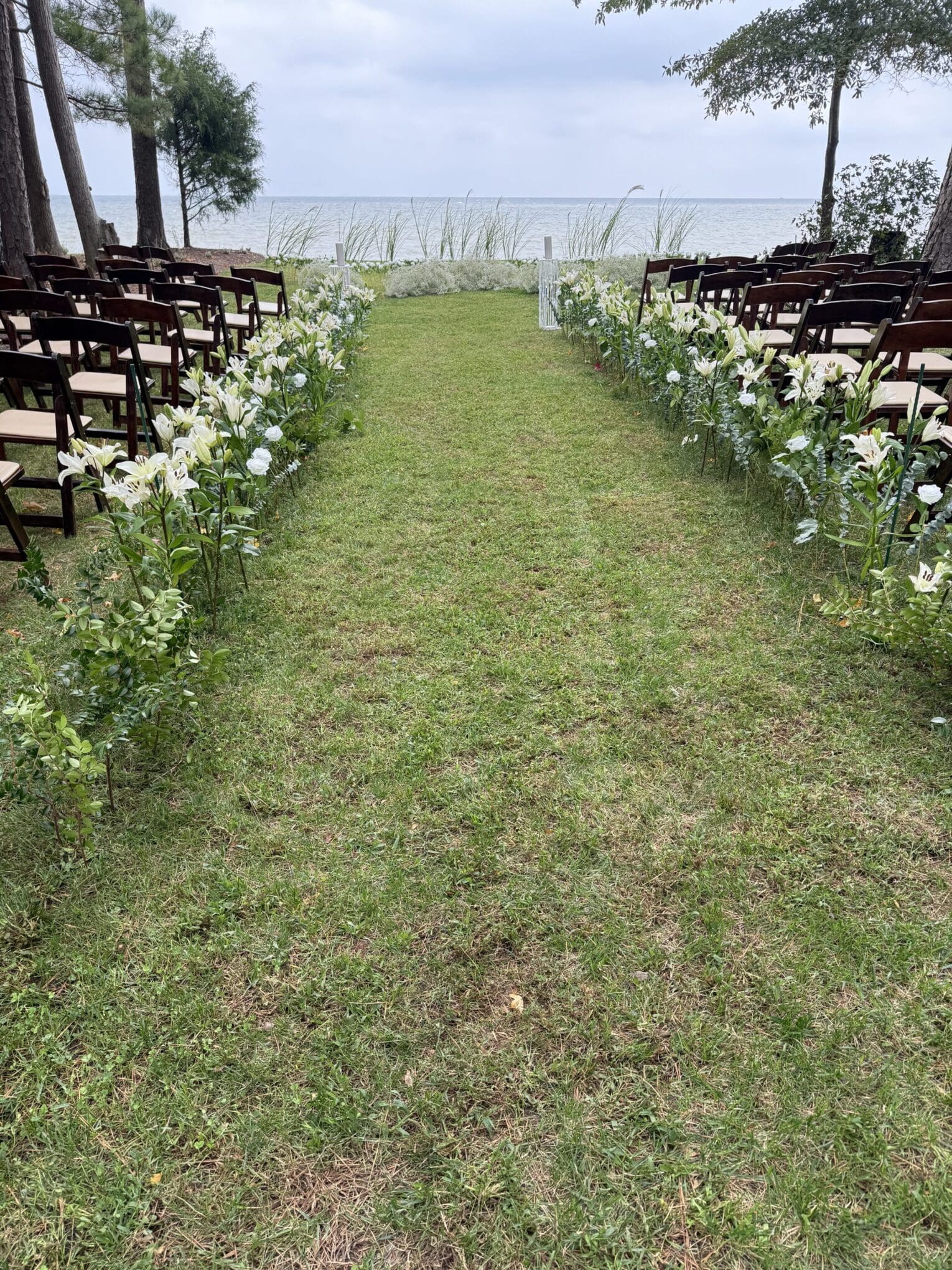 Simple sprays of Lilies and eucalyptus greenery presents an opulent Wedding Isle. The Chesapeake Bay is the only backdrop needed
